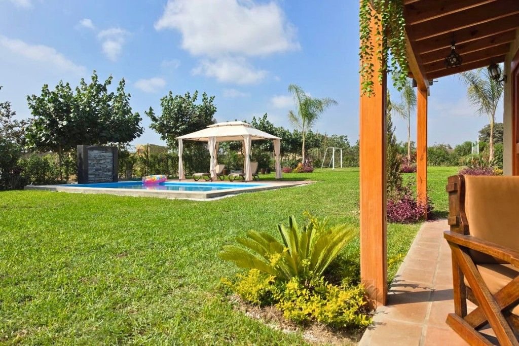 Piscina con toldo en el jardín