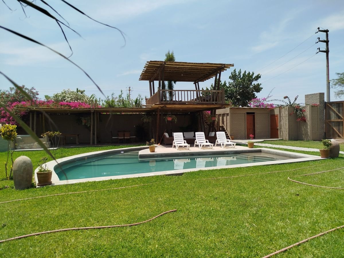 Piscina compartida del condominio rodeada de jardines